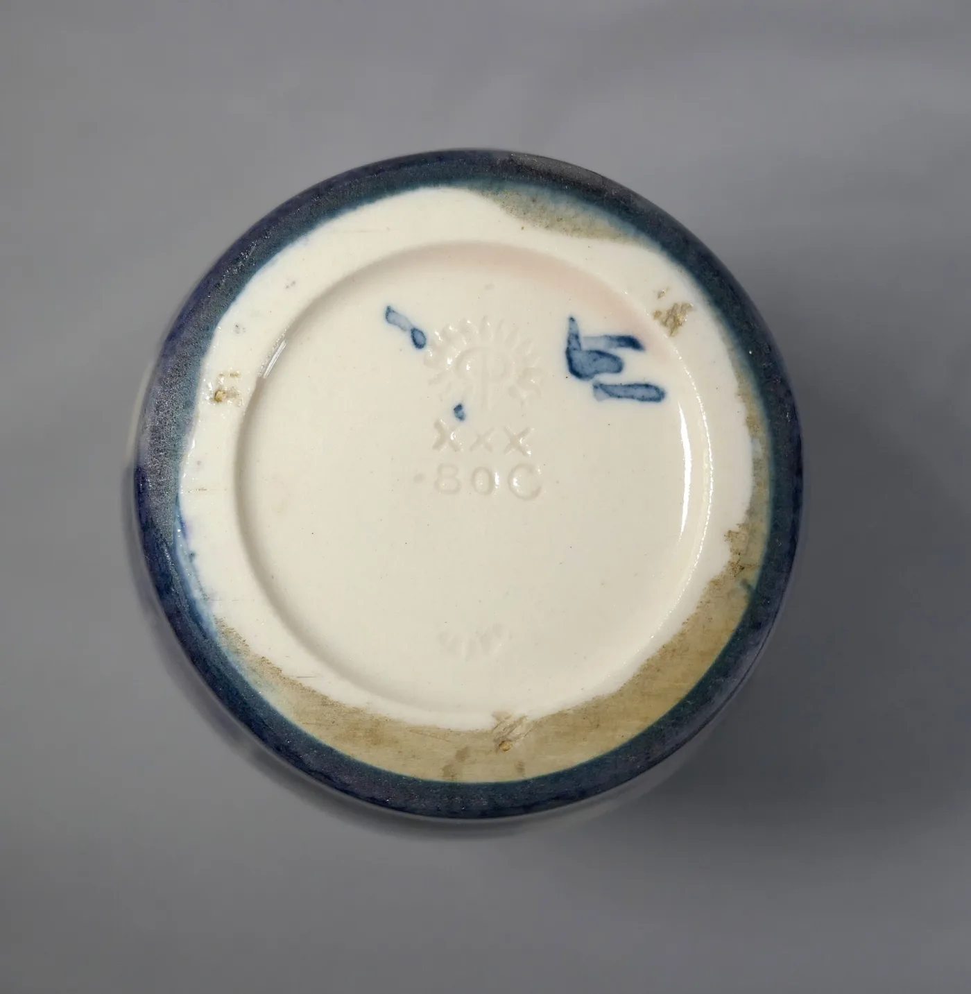 Underside of a ceramic vase showing an unglazed white foot ring around a recessed base, impressed with a flame-and-RP monogram, a row of small flames, a Roman numeral and the shape number 80C