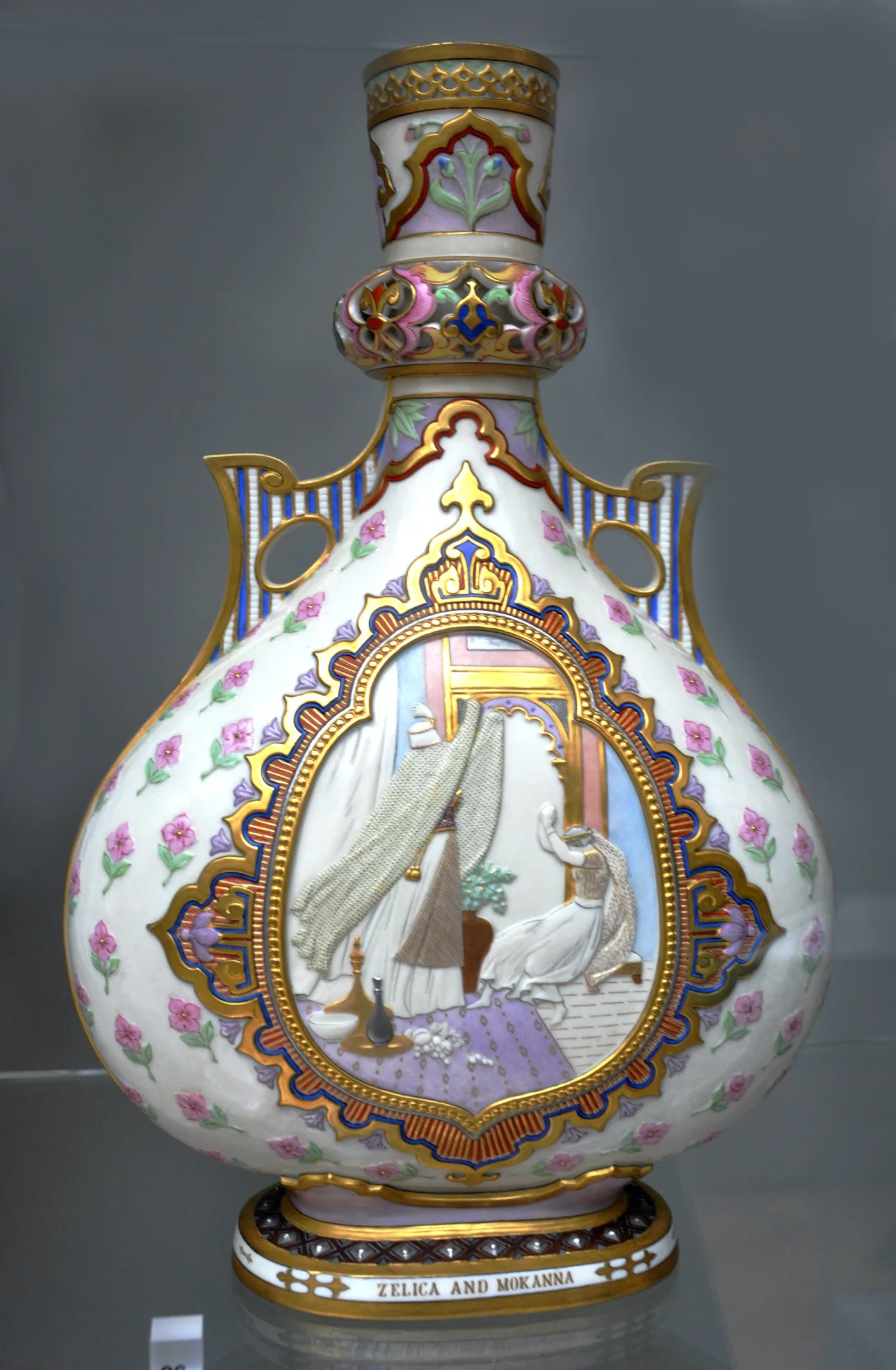 Tall flask-shaped vase with an ivory ground, raised white figures inside a gilded arched panel, a pierced neck and handles, and a titled foot rim