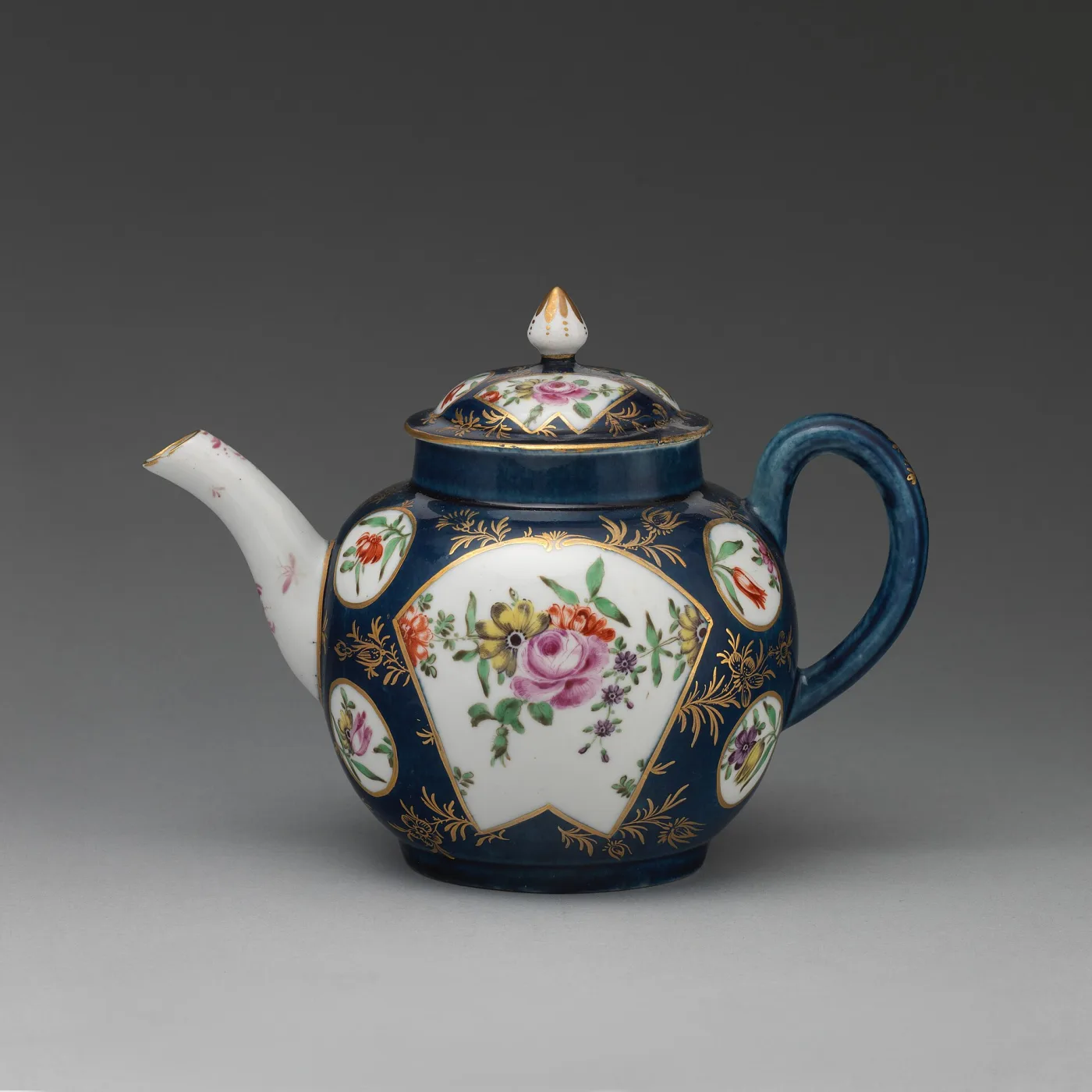 Globular teapot with a deep blue ground broken by white panels of painted flowers, with a gilt-edged domed cover