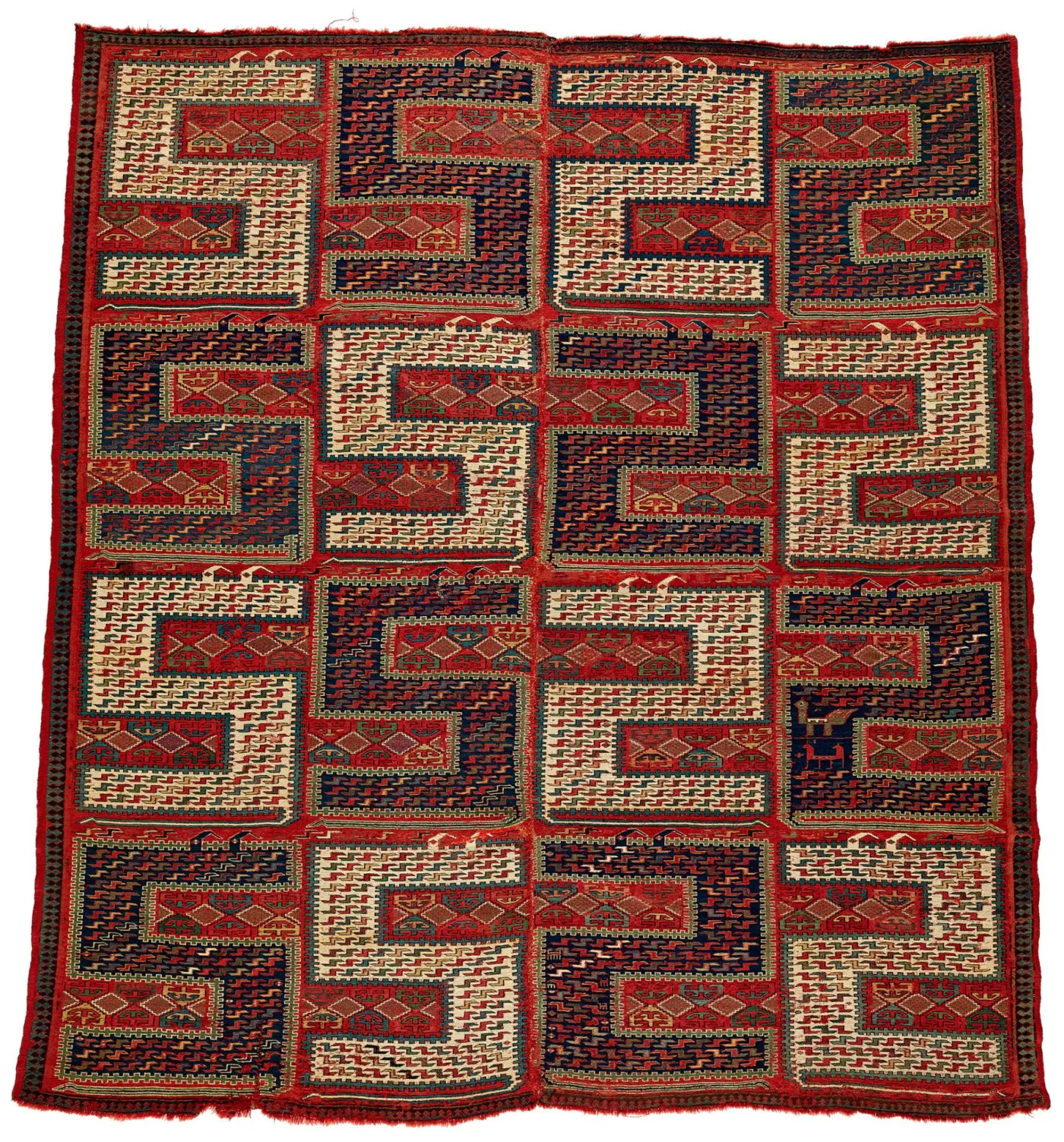 Caucasian flatweave rug of 1875 to 1925 with a bold repeating pattern of hooked and latch-hook forms in dark wool on a red ground