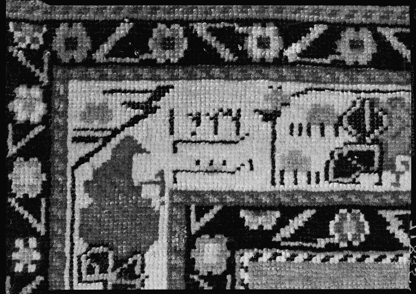 Detail of a Marasali Shirvan prayer rug showing a woven inscription panel in the border containing Arabic numerals and characters knotted into the pile