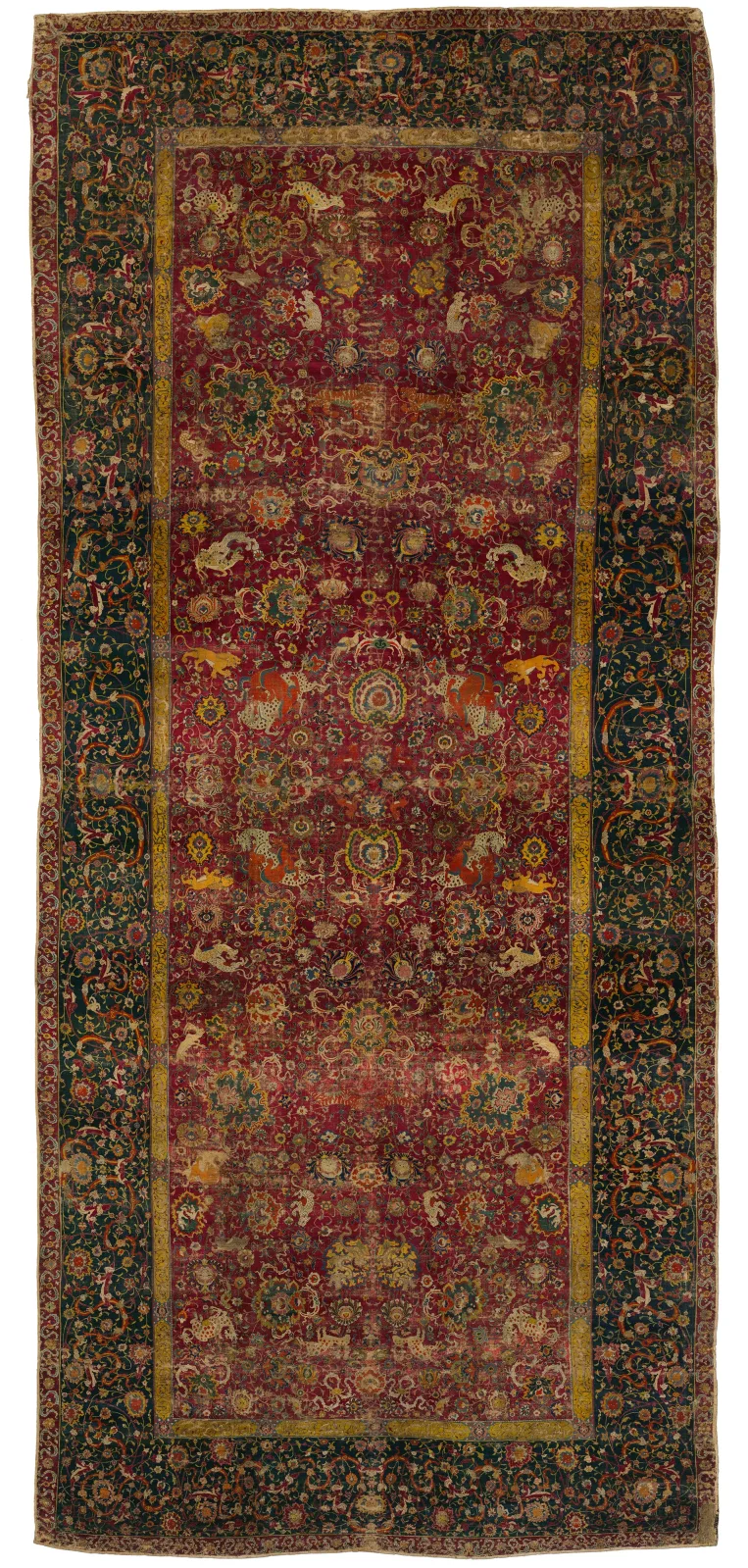The Emperor's Carpet, a long sixteenth century Persian carpet with a deep red field covered in dense scrolling floral and animal ornament inside a dark green border