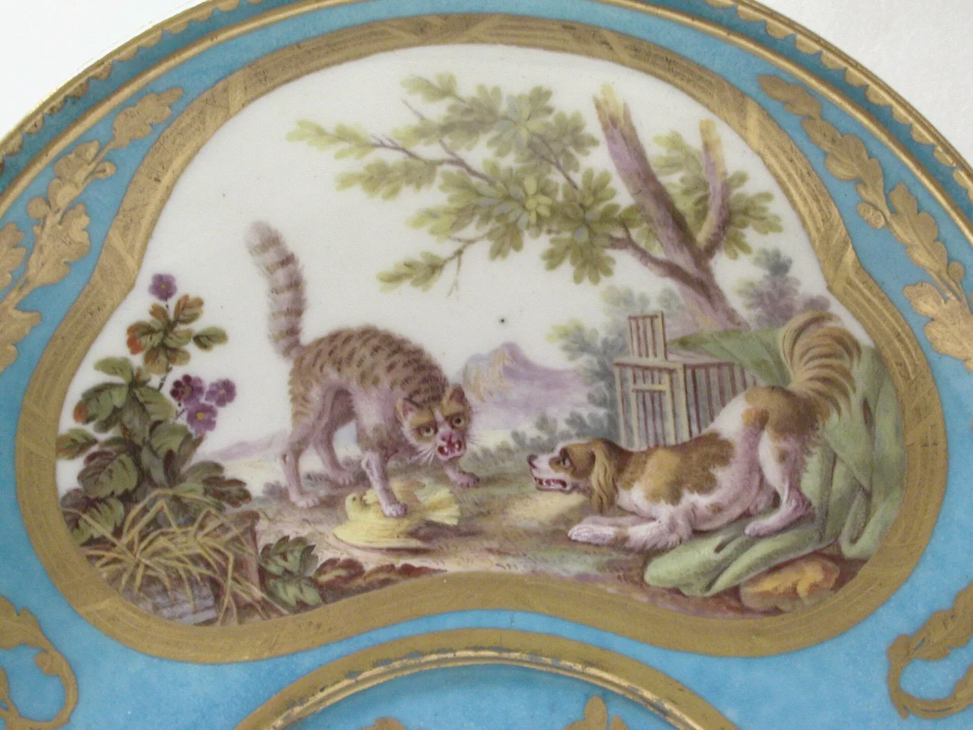 Painted reserve on a turquoise Sèvres tray showing a bristling cat facing a spaniel beneath an oak tree, framed in tooled gilding