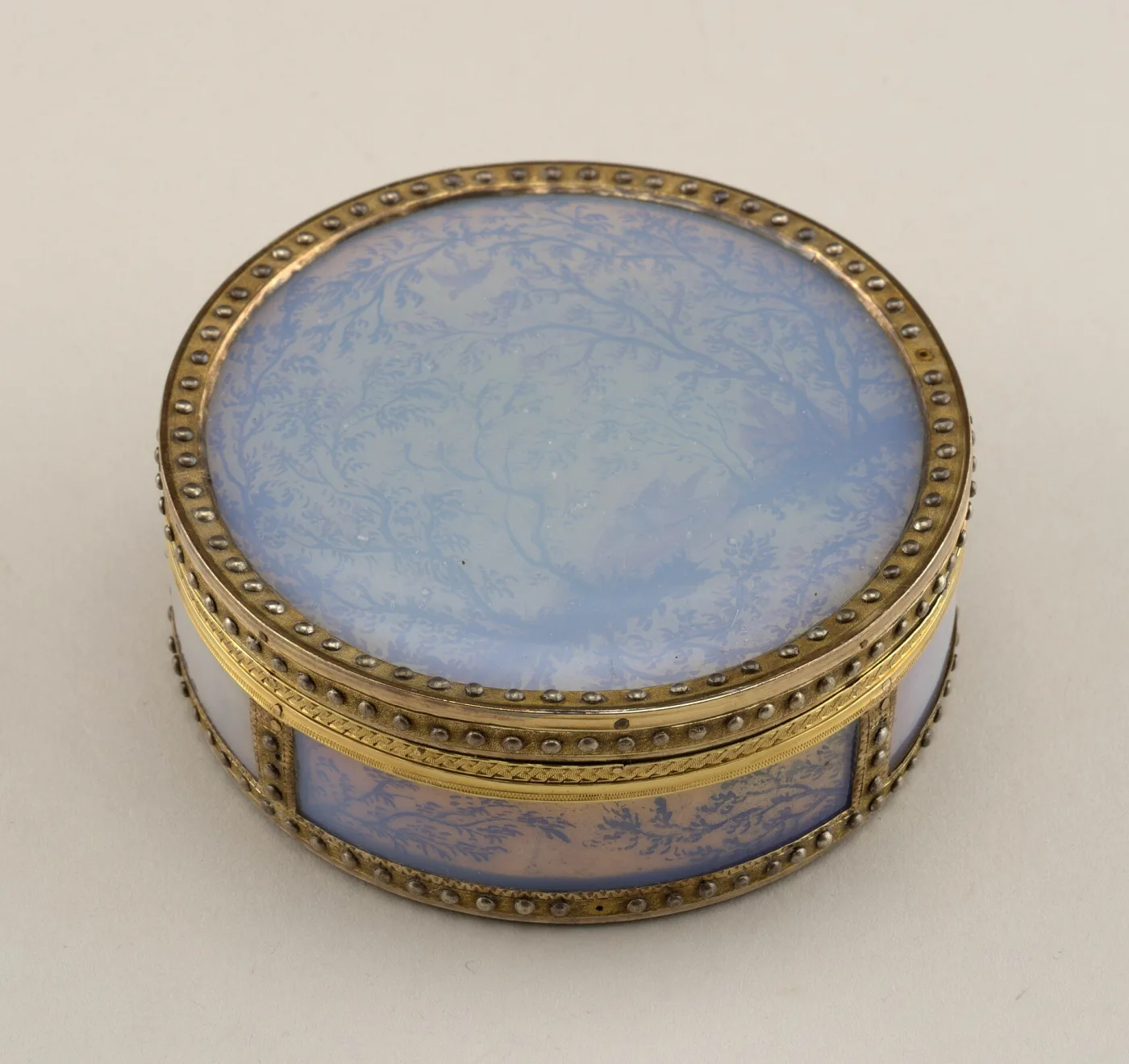 Circular snuff box dated 1779 with a pale blue enamel lid inside a beaded gilt rim