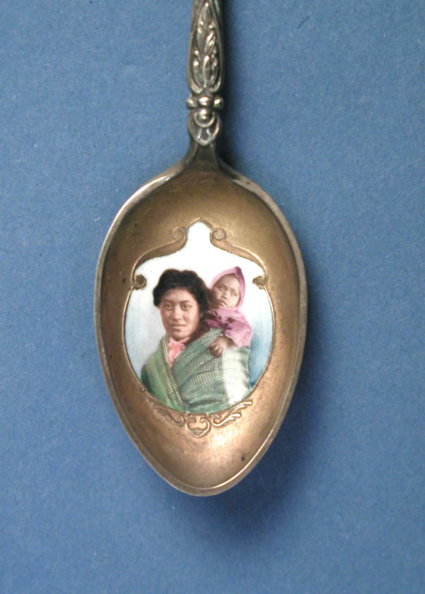Gilded spoon bowl inset with a hand-coloured photographic enamel portrait of a woman carrying a child