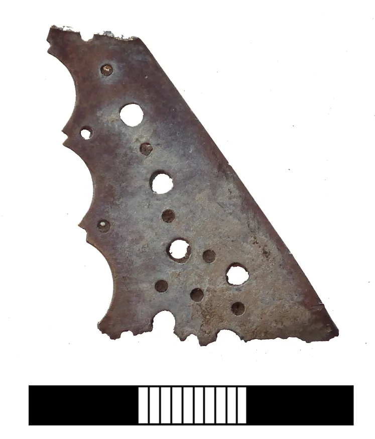 Detached triangular gnomon of sheet copper, pierced with rows of large and small round holes and cut with a scalloped edge, the tip broken away