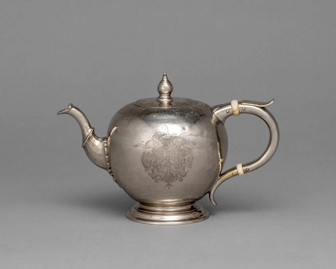 Globular American silver teapot of 1740 by Jacob Hurd with a wooden handle and domed lid