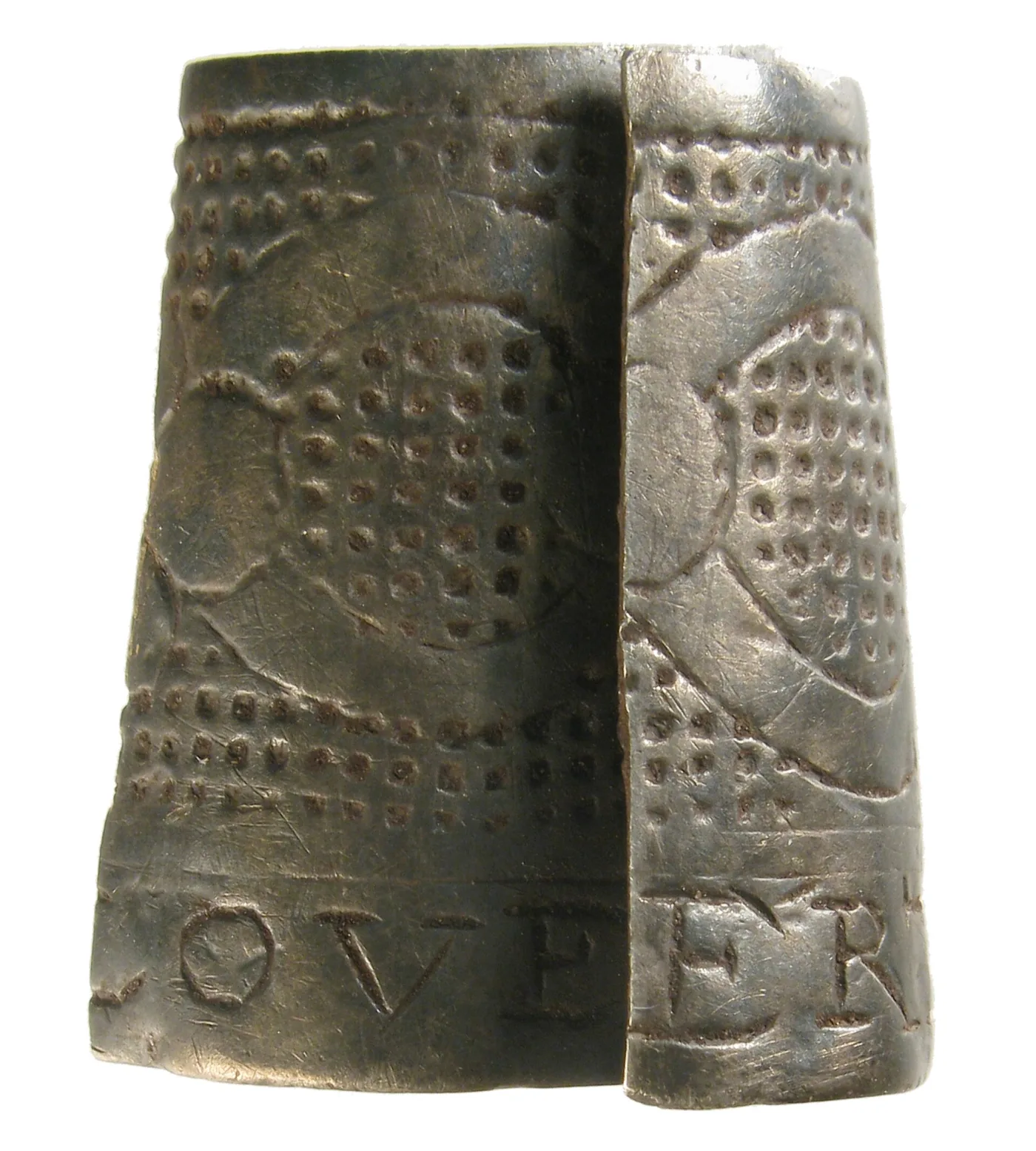 Incomplete seventeenth-century silver thimble, split open and flattened, showing irregular rows of hand-punched indentations above a band of engraved capital letters