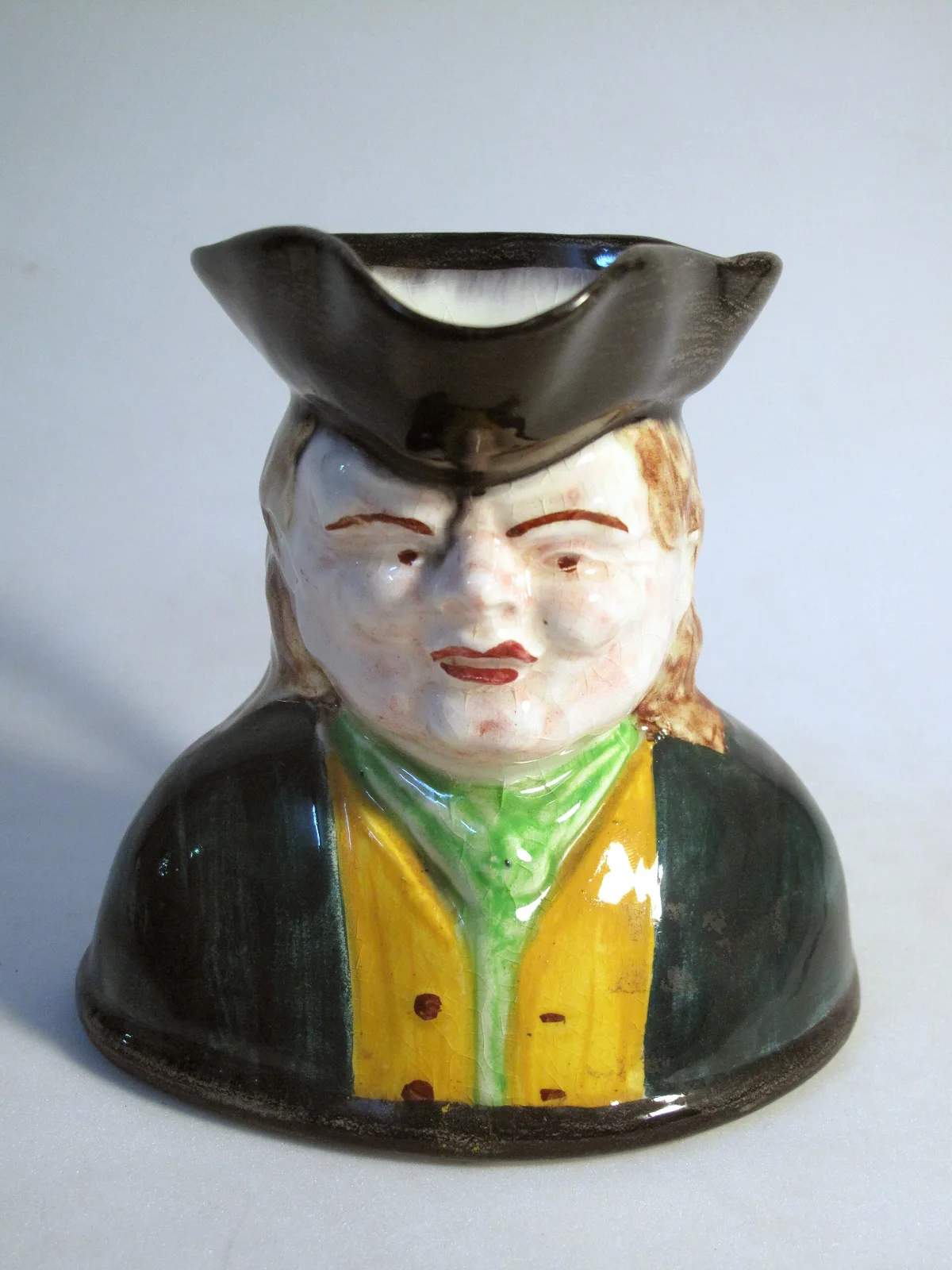 Jug modelled as the head and shoulders of a man in a tricorn hat, his hair falling to the sides, the handle formed at the back