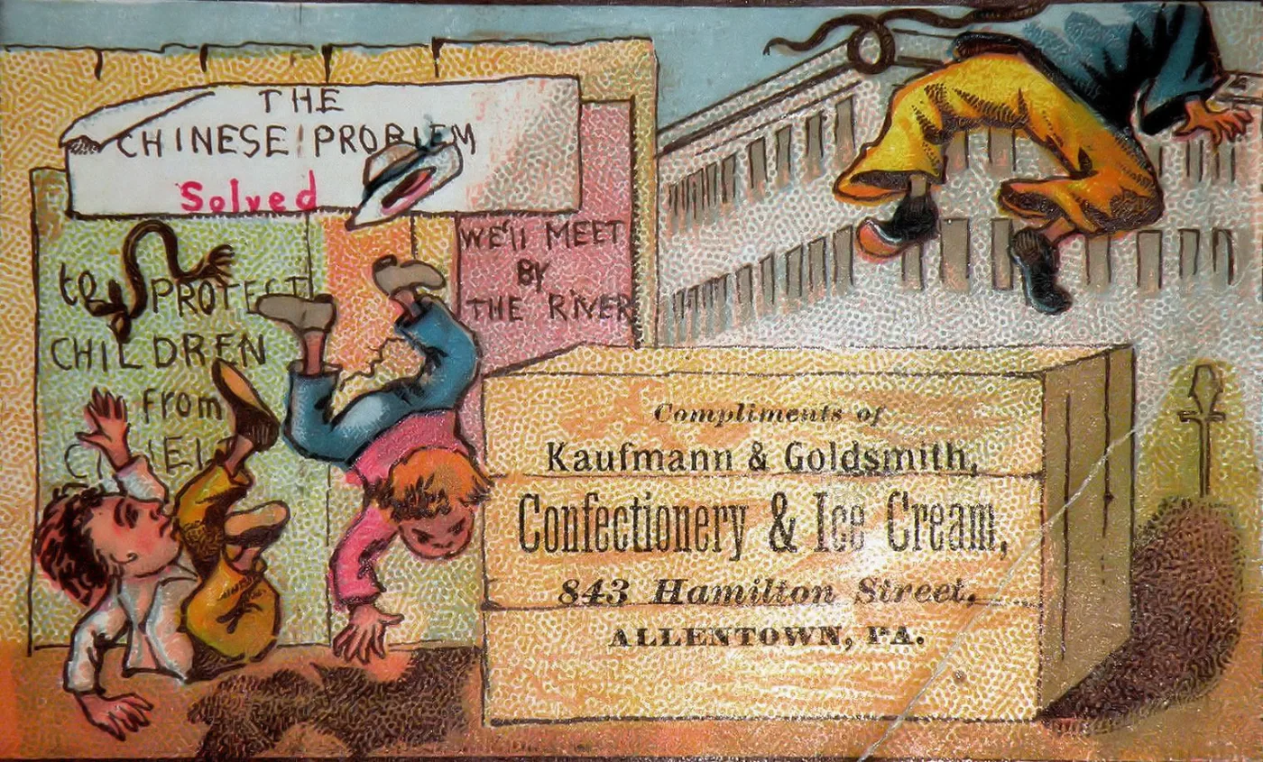 Colour advertising card of 1885 showing cartoon figures climbing over a crate on a wharf, with the local confectioner's name and Allentown address printed in a plain block at the lower right