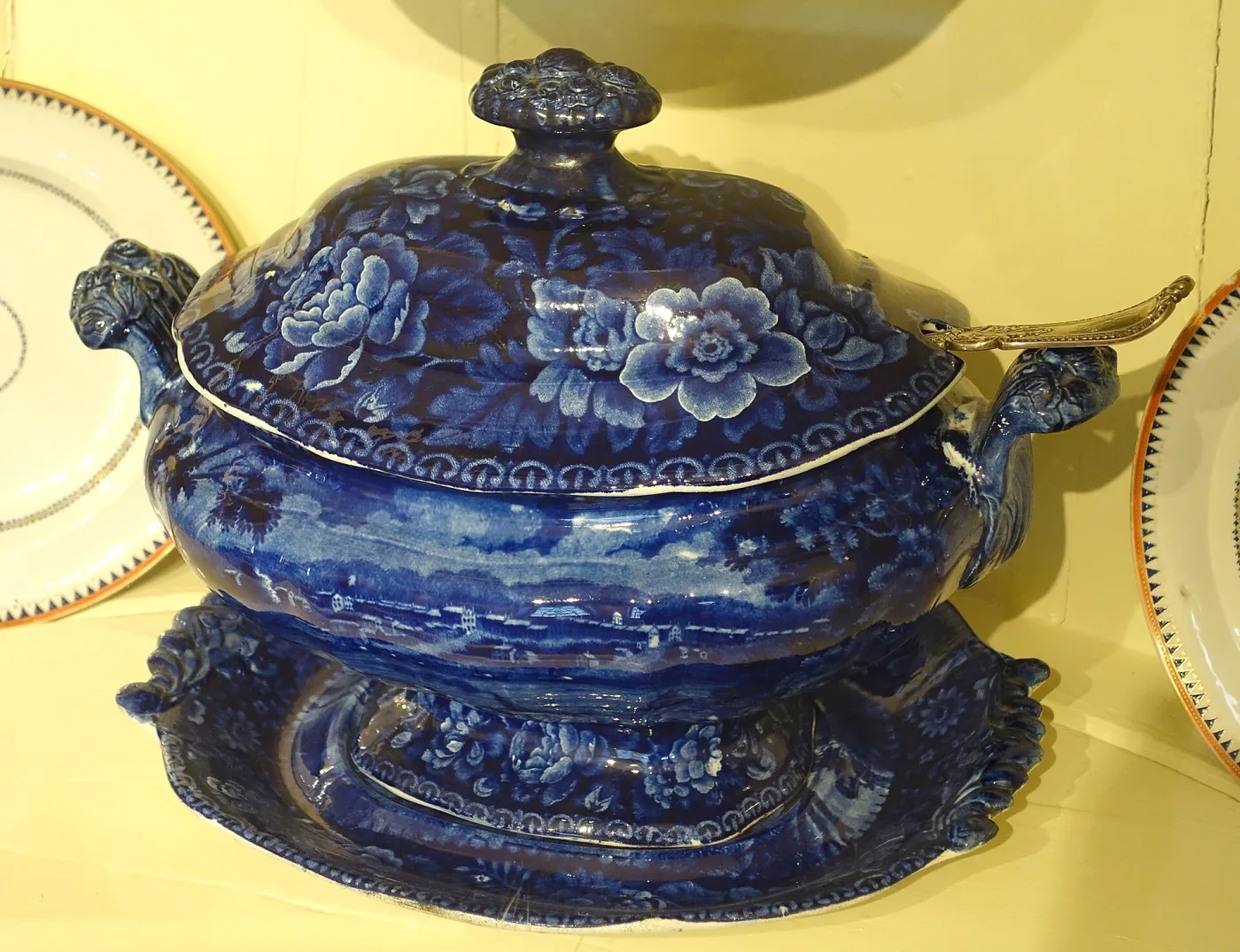 Covered soup tureen and matching stand printed in deep dark blue with floral and scenic decoration, the cover with a moulded finial and the body with scrolled handles