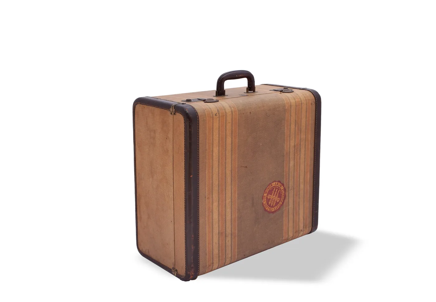 Flat rectangular suitcase covered in vertically striped material with tan leather corners and binding, a single handle on the long edge and two small catches beside the central lock