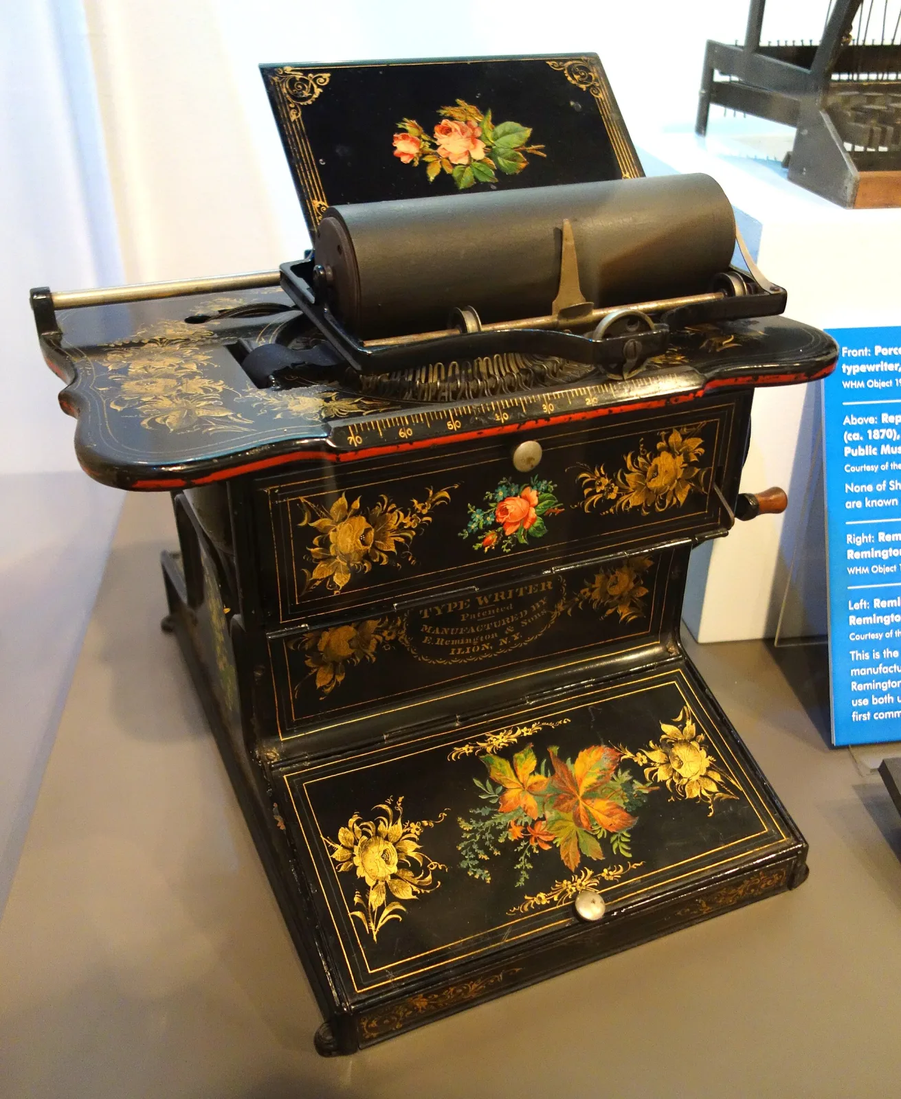 Remington No. 1 typewriter of the 1870s, its black japanned body painted with sprays of flowers, mounted on a cast-iron treadle stand with a fold-down side table