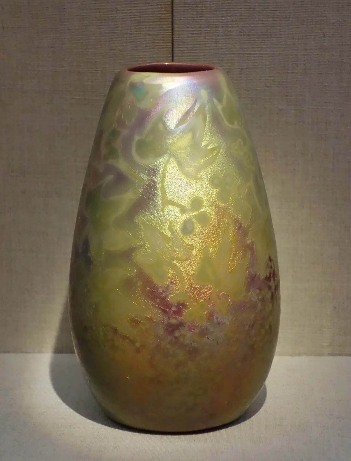 Ovoid vase with a lustre glaze shading from olive-green at the shoulder to rose and gold below, decorated with soft cloudy floral forms that emerge from the ground