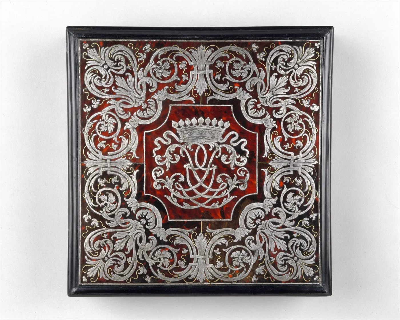 Writing box of about 1715 with a sloped lid veneered in red tortoiseshell inlaid with scrolling brass arabesques, framed by a broad band of engraved brass foliage