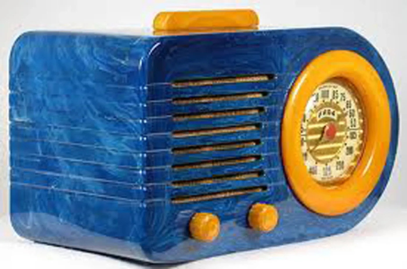 Streamlined table radio in bright blue cast plastic with a rounded bullet-shaped body, a yellow dial bezel and knobs, and horizontal grille slots across the front