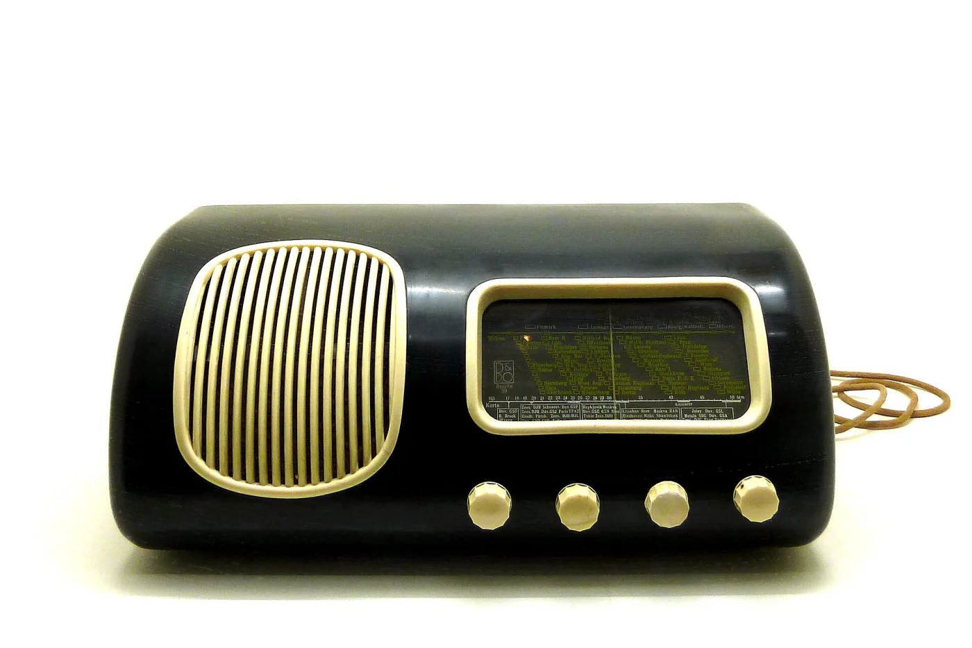 Dark brown table radio of 1939 with a rounded moulded case, a wide horizontal speaker grille of cast bars, a small dial window and three small knobs along the base