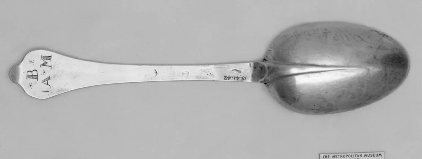 Back of an English silver spoon of 1701 with a rounded wavy-end terminal, a rat-tail down the bowl and hallmarks in a line on the stem