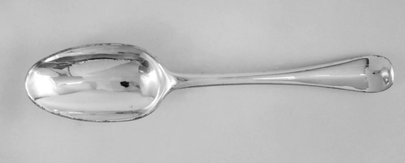 English Hanoverian pattern silver spoon of 1718 with a rounded terminal and a raised ridge running down the stem