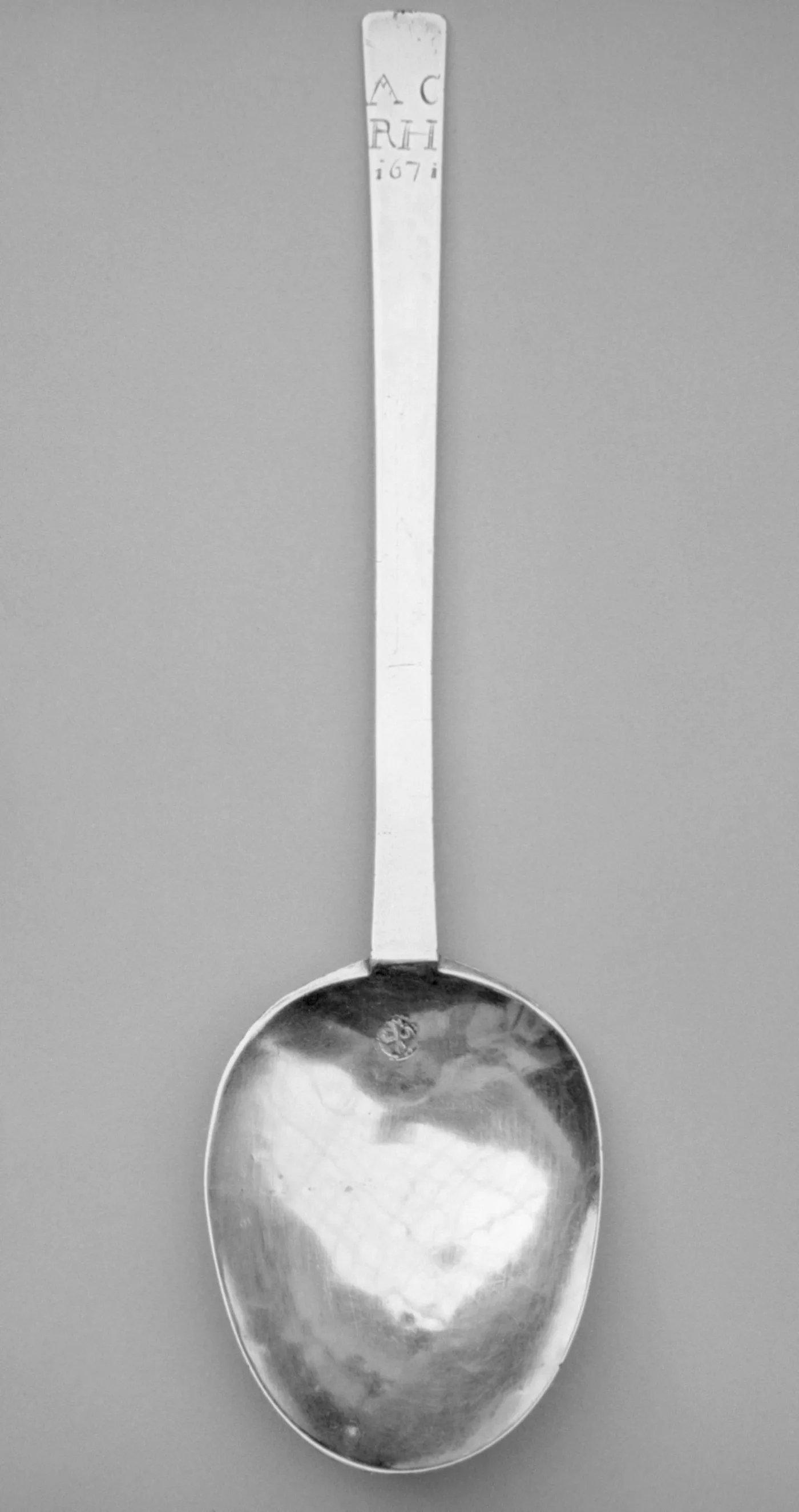 Puritan spoon of about 1670 with a plain flat stem cut square at the end, pricked with owners' initials and the date 1671