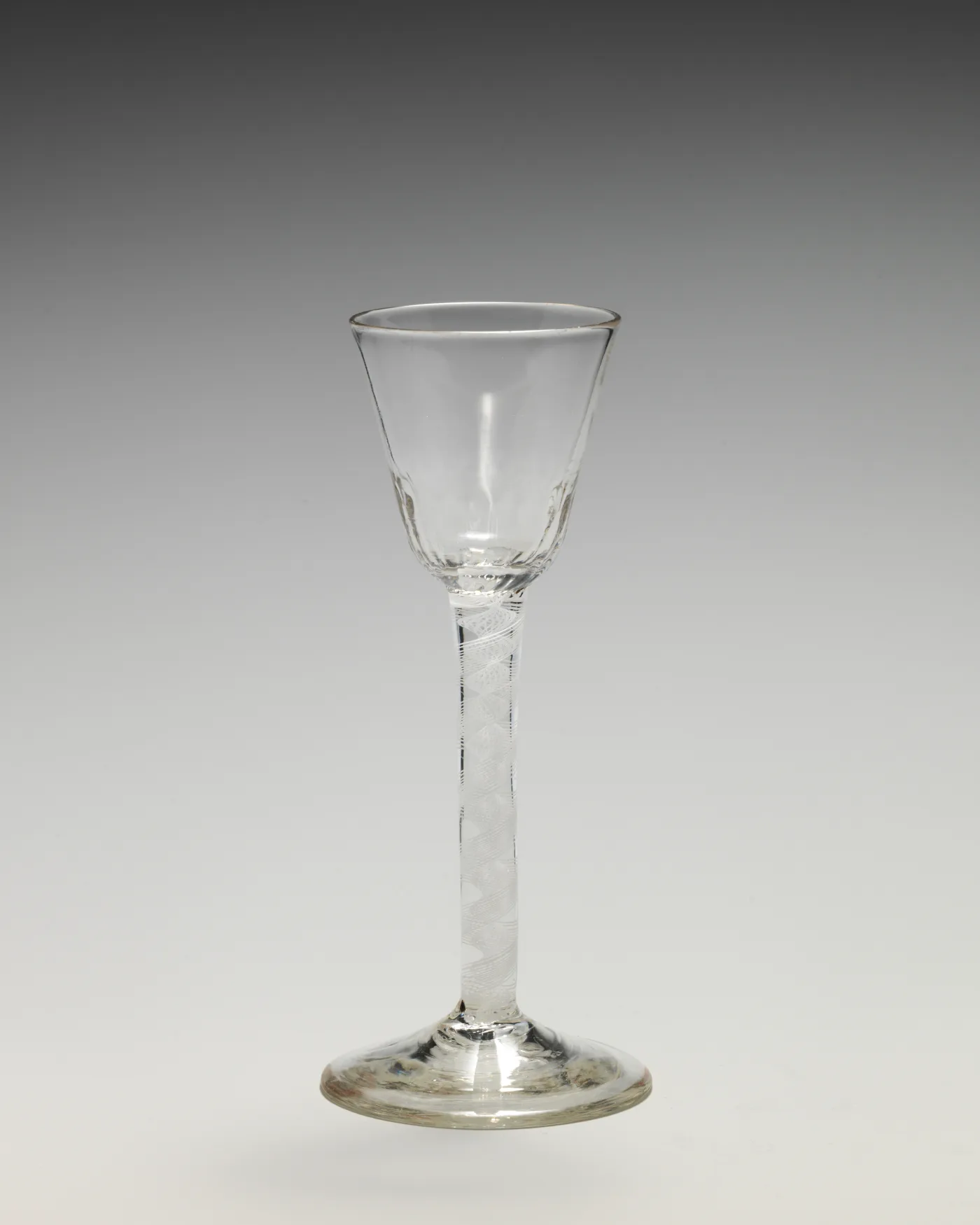 English wine glass with a slender stem covered in small wheel-cut diamond facets and fluting around the base of the bowl
