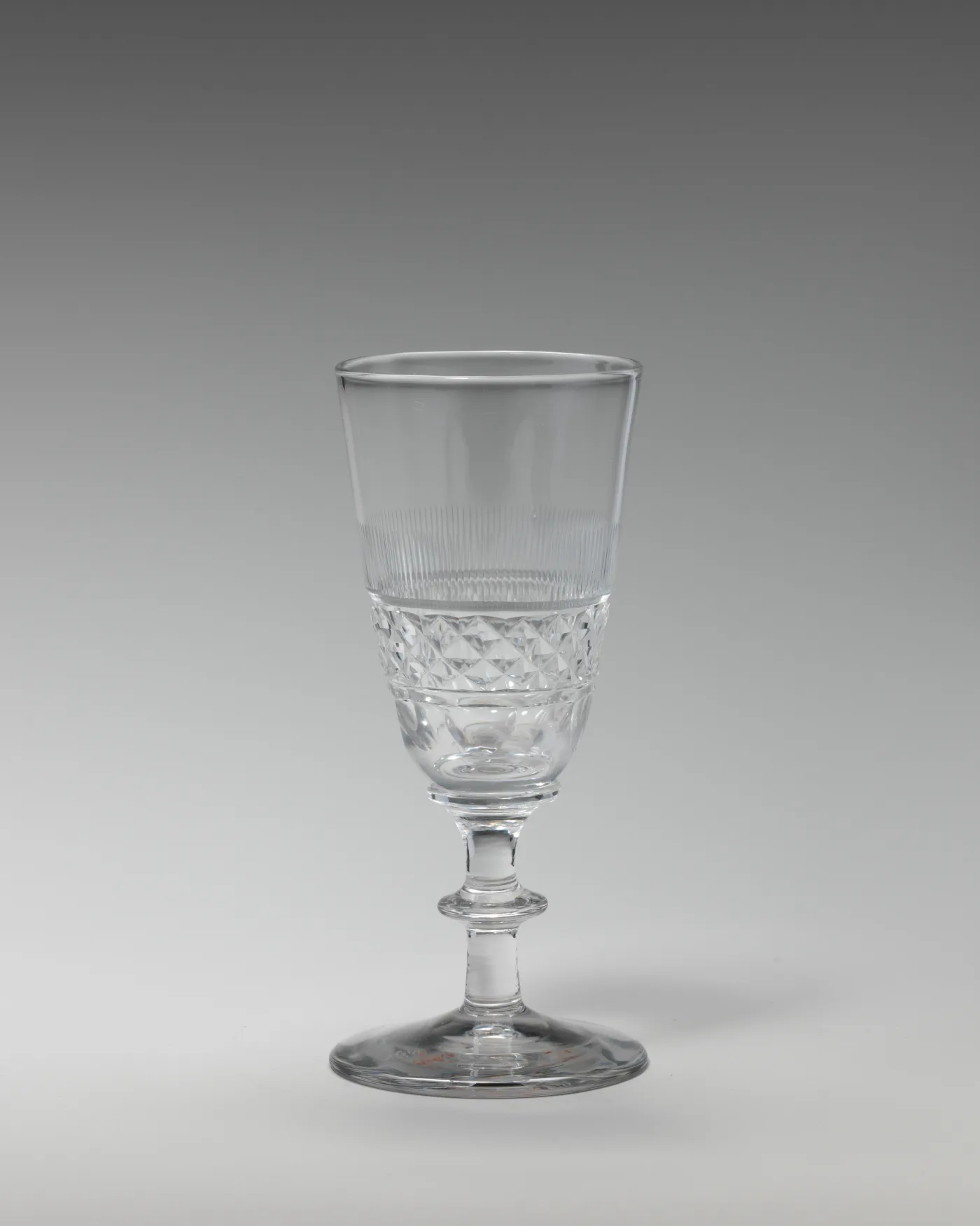 English wine glass with flute cutting above a band of diamond cutting on the bowl, over a short stem with a collar knop