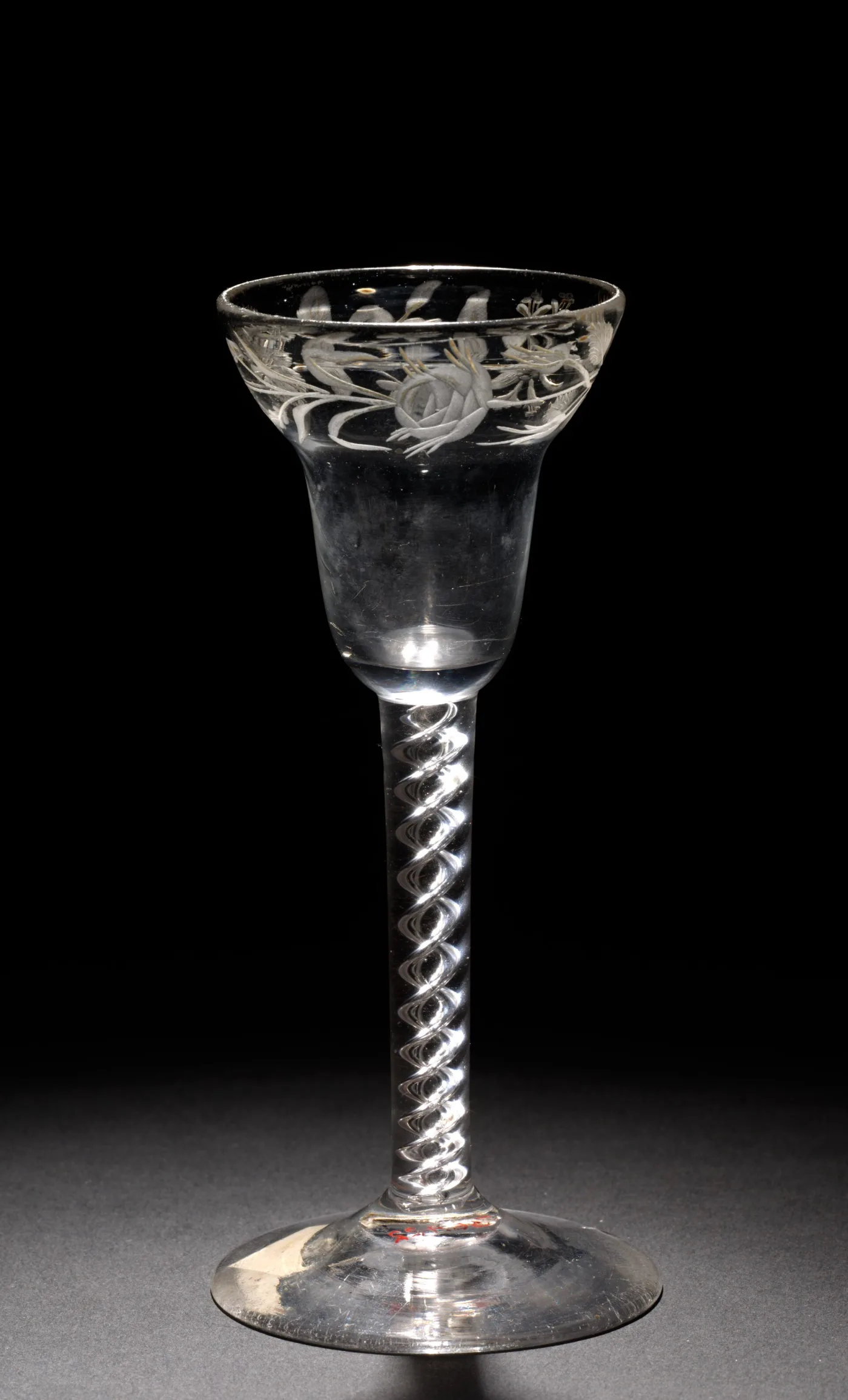 English air twist wine glass with a bell bowl wheel-engraved with a rose and a half-open bud above a spiral air twist stem