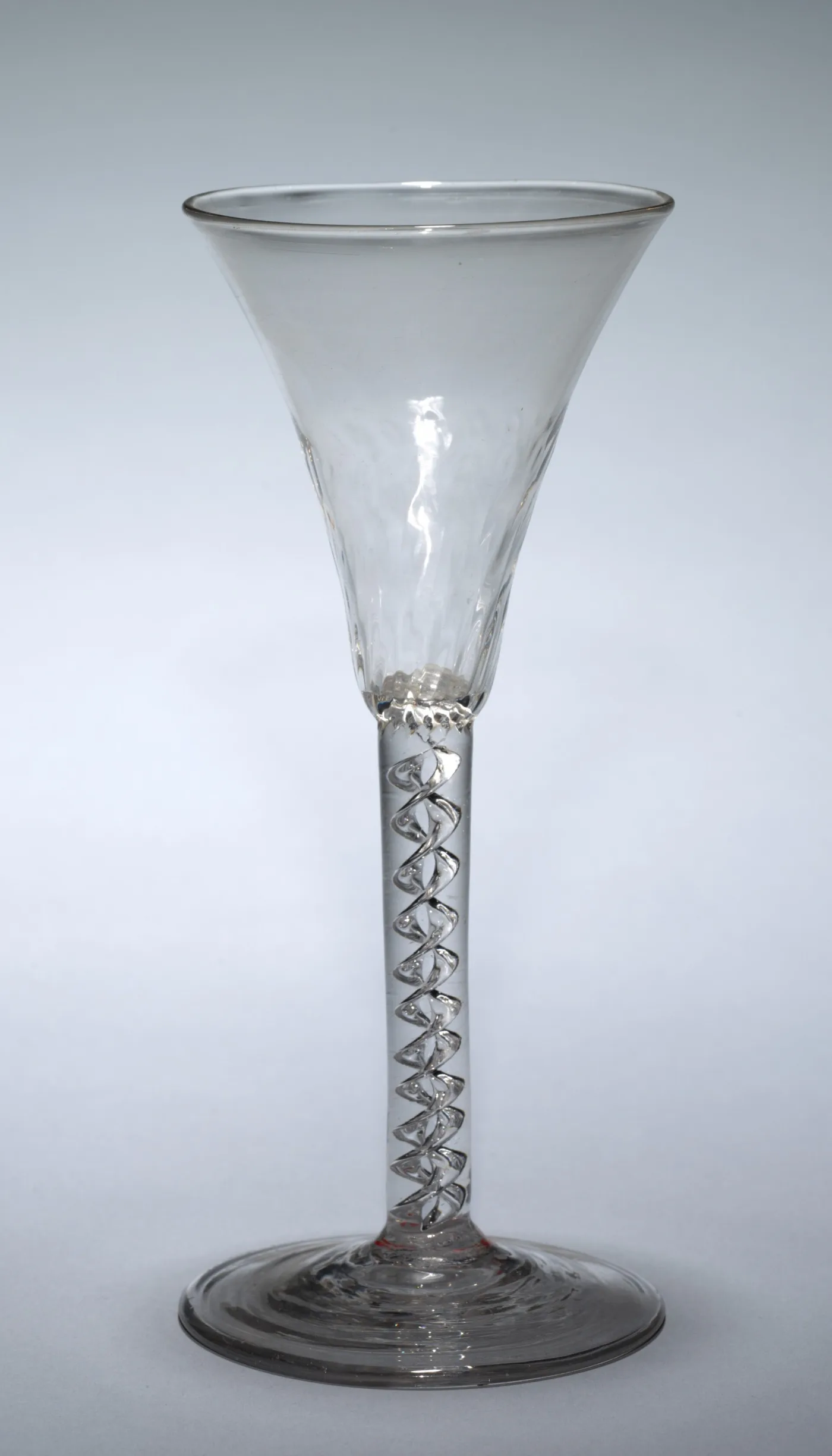 English air twist wine glass of about 1740 with a moulded trumpet bowl and a bold spiral of trapped air in the stem