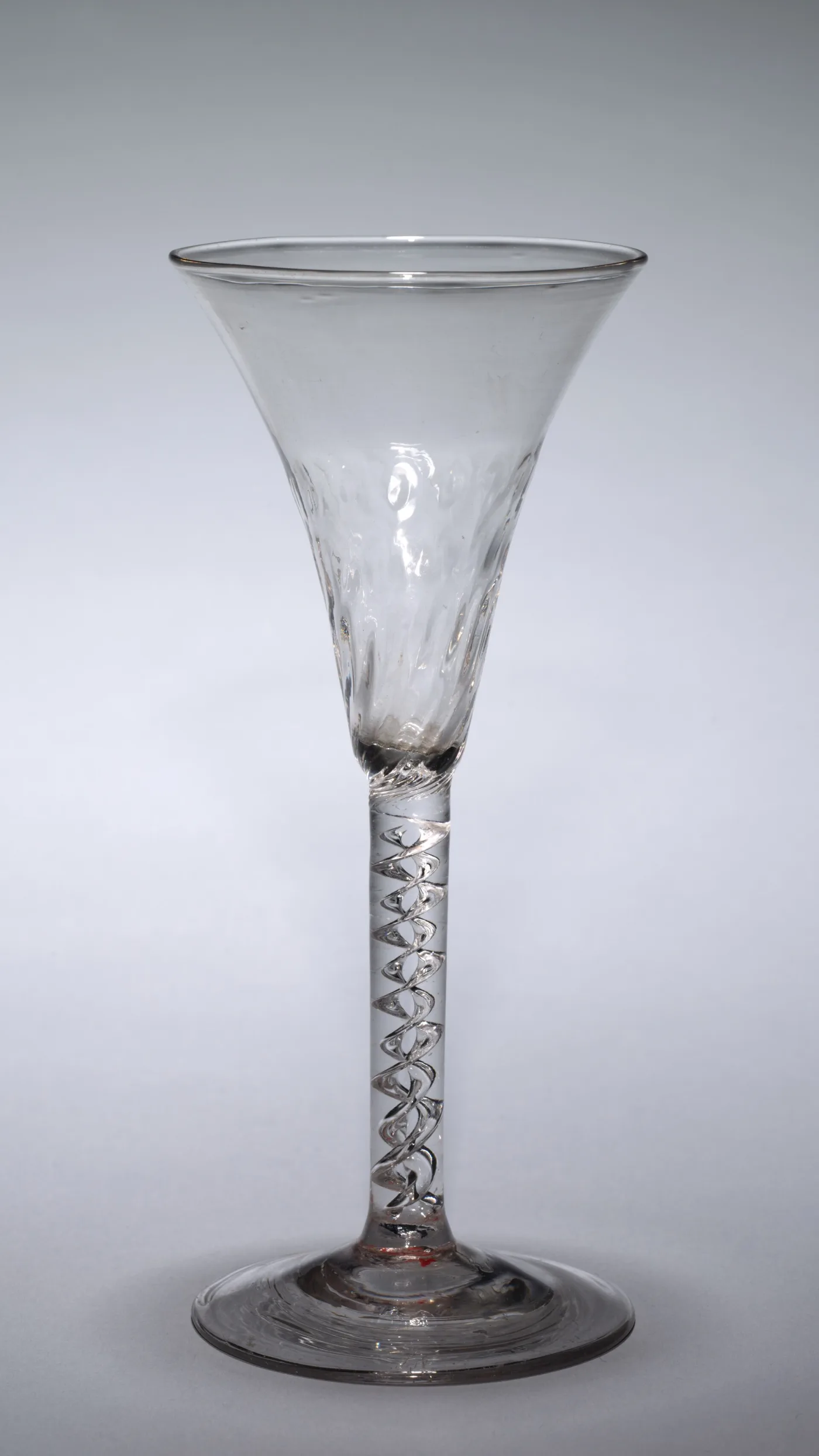 English air twist wine glass of about 1740 to 1750 with fluting moulded around the base of the bowl