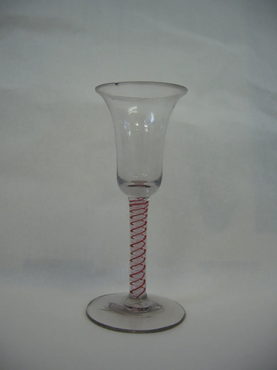 English colour twist wine glass with red threads spiralling the full length of a clear stem below a bell bowl