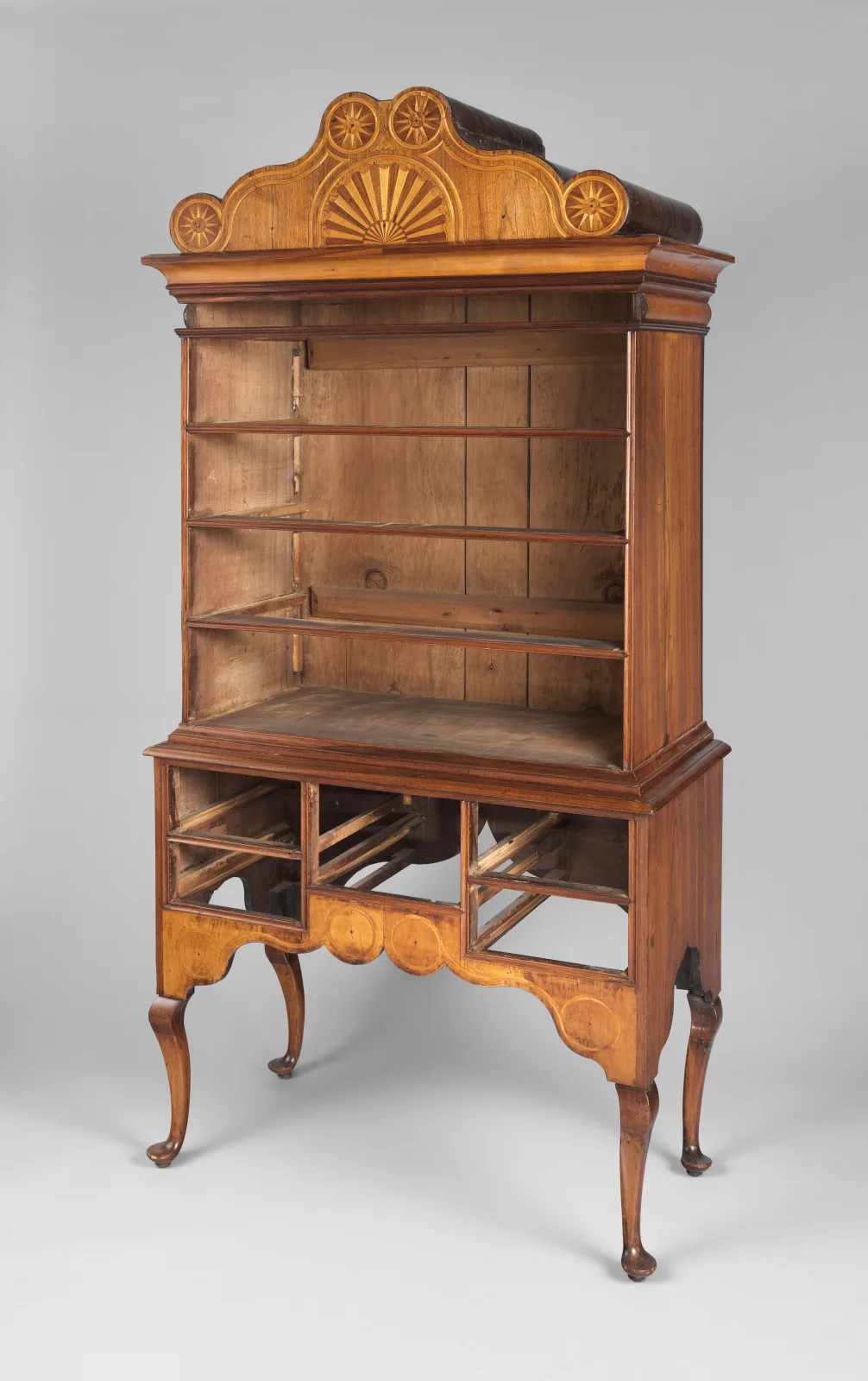 A walnut high chest of drawers with every drawer removed, showing the empty shelves and runners of the upper case and the open compartments of the lower case