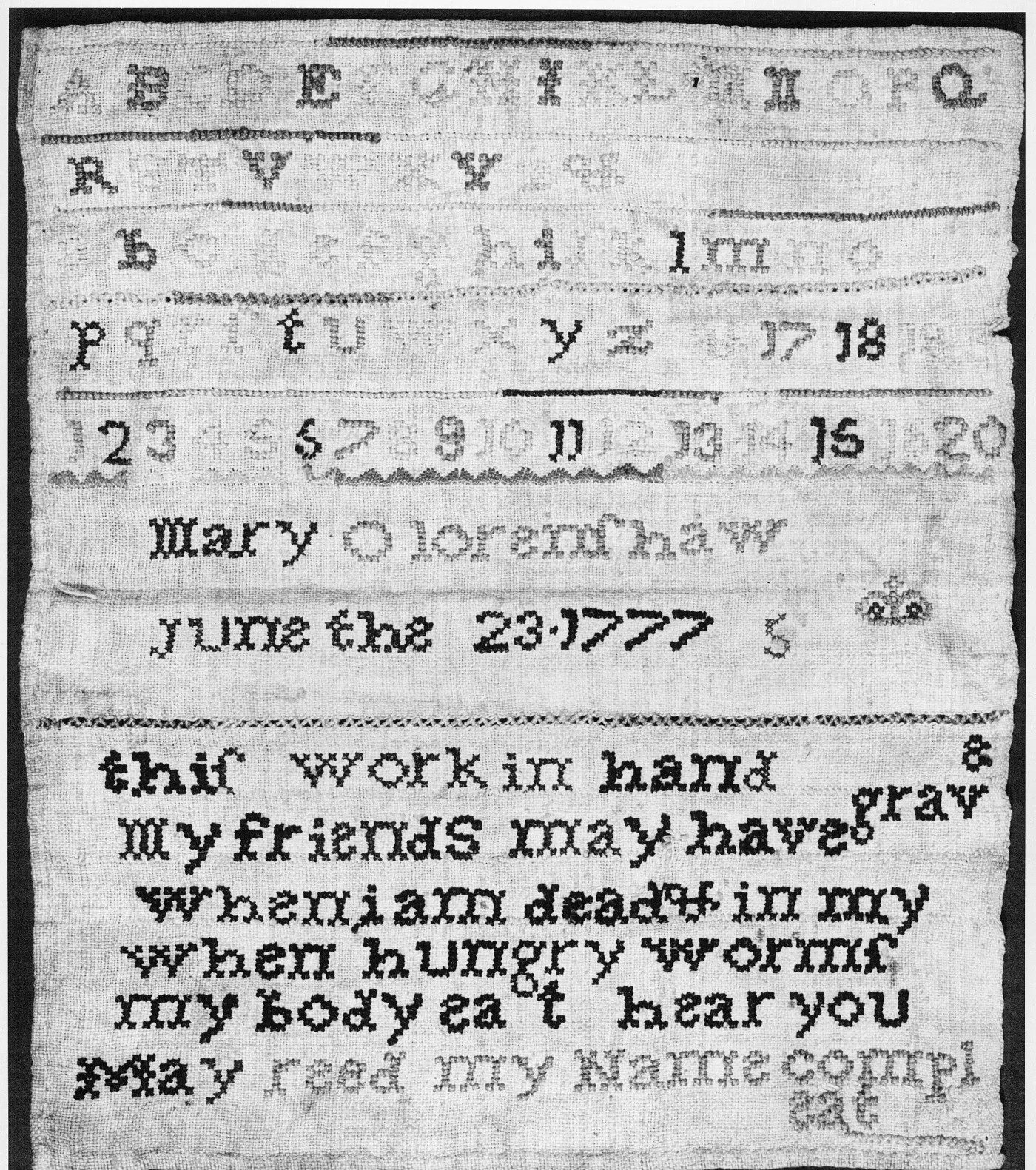 Black and white photograph of a linen sampler with alphabets, numbers, the name Mary Olorenshaw, June the 23 1777, and a six-line rhyme in heavy cross stitch