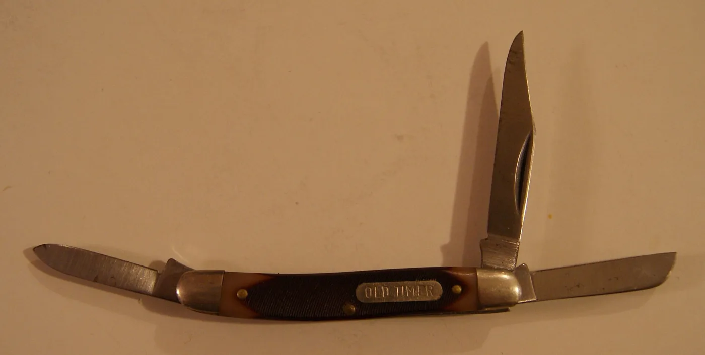 Schrade Old Timer three-blade stockman pocket knife with brown sawcut handles, an OLD TIMER shield and nickel silver bolsters, with two blades open
