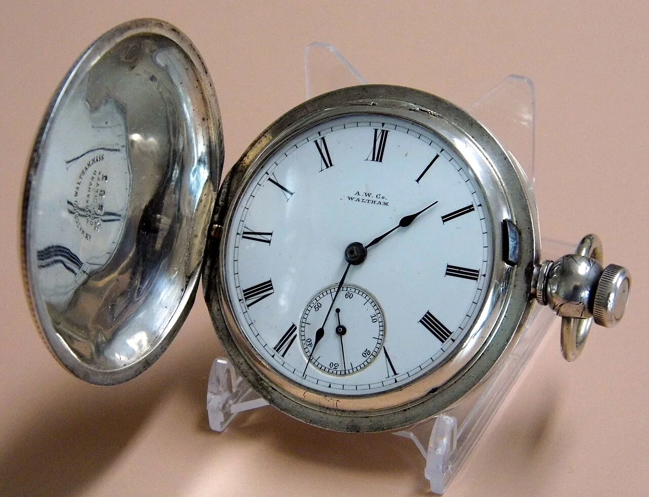 Silver hunting-case pocket watch with a white enamel dial, black Roman numerals and A.W.Co. Waltham printed below twelve
