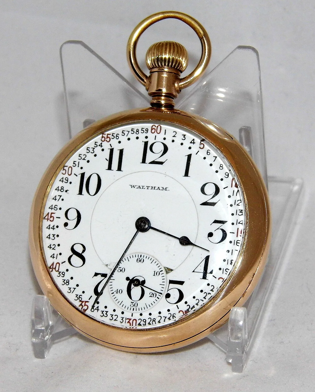 Open-face gold-coloured pocket watch with a white dial, large black Arabic numerals, every minute numbered around the edge and the crown at twelve