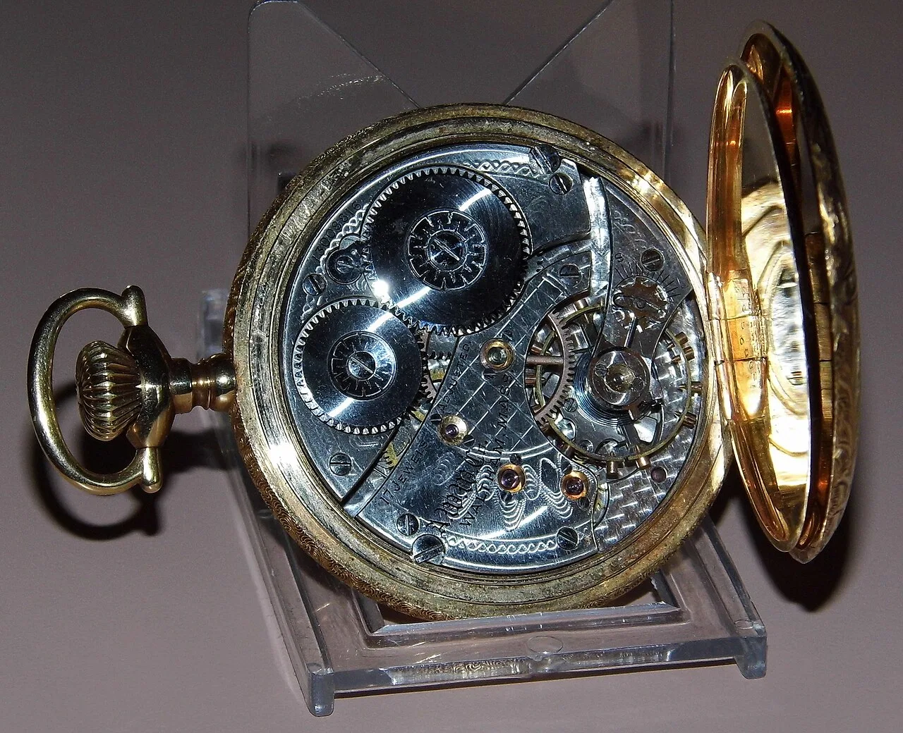 Pocket watch movement with damascened nickel plates inside an open hunting case of yellow gold, the front cover swung back