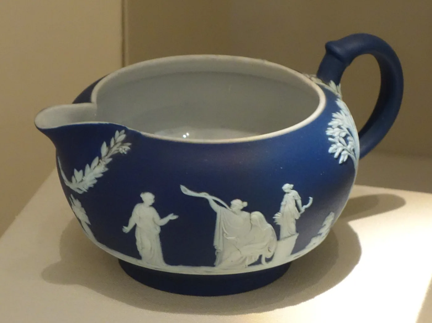 Dark blue Wedgwood jasper cream jug photographed from above, showing a plain white interior against the blue exterior
