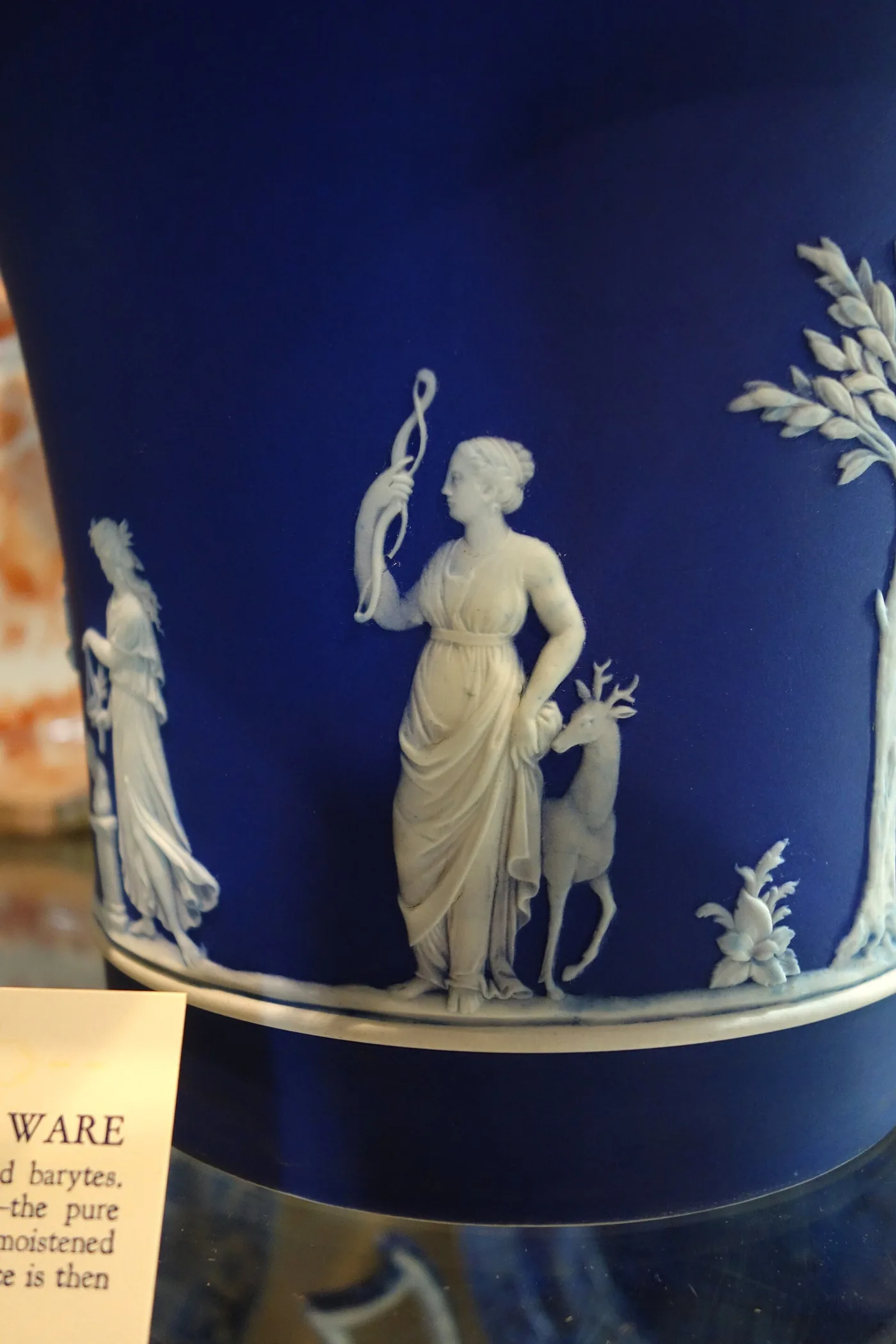 Close view of white applied relief figures of Diana with a stag on a dark blue Wedgwood jasper ground